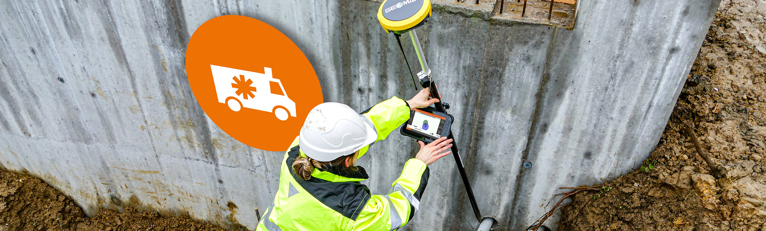 Worker in high-vis onsite using GeoMax positioning tool with tablet